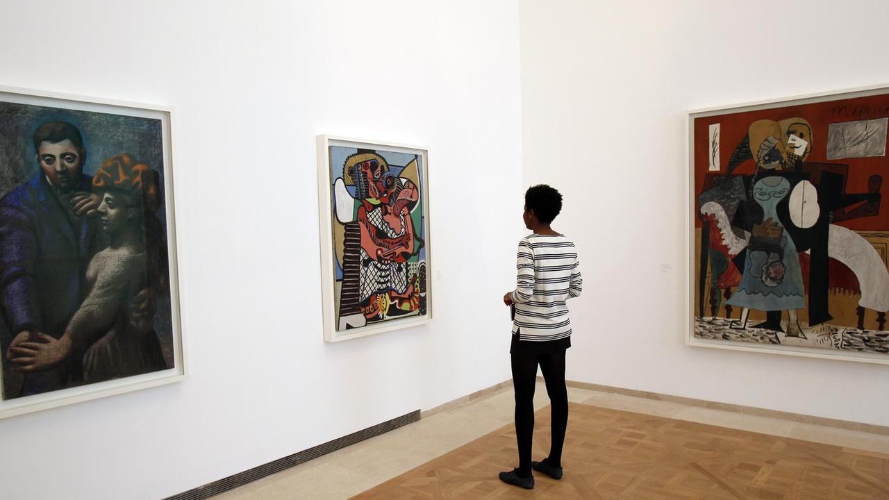 Eine Besucherin betrachtet Gemälde im Musée Picasso in Paris.