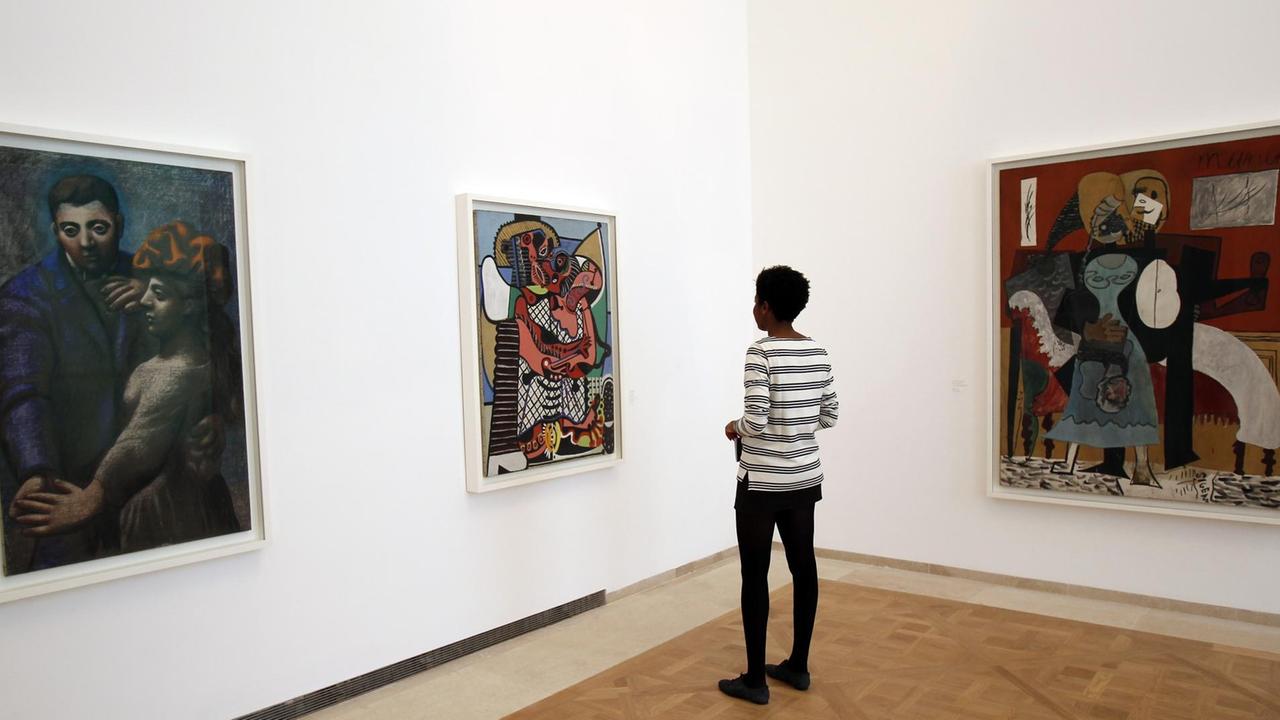Eine Besucherin betrachtet Gemälde im Musée Picasso in Paris. Eine Besucherin betrachtet Gemälde im Musée Picasso in Paris.