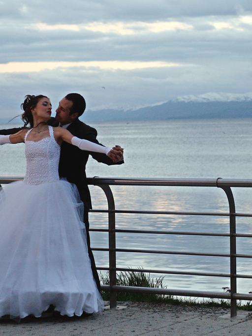 Ein Brautpaar posiert für Hochzeitsfotos im Hafen von Ushuaia auf Feuerland