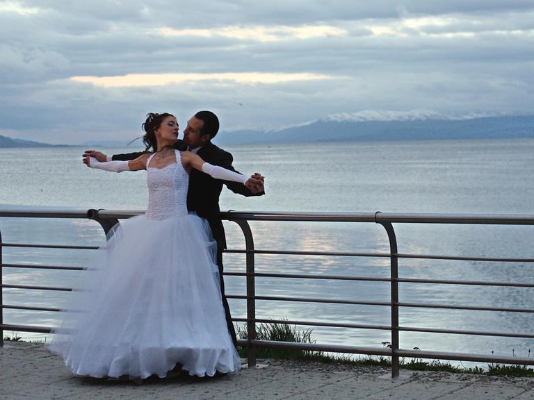 Ein Brautpaar posiert für Hochzeitsfotos im Hafen von Ushuaia auf Feuerland