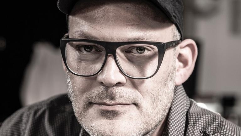 Porträt von Dominik Günther mit Brille und schwarzem Basecap. Porträt von Dominik Günther mit Brille und schwarzem Basecap.
