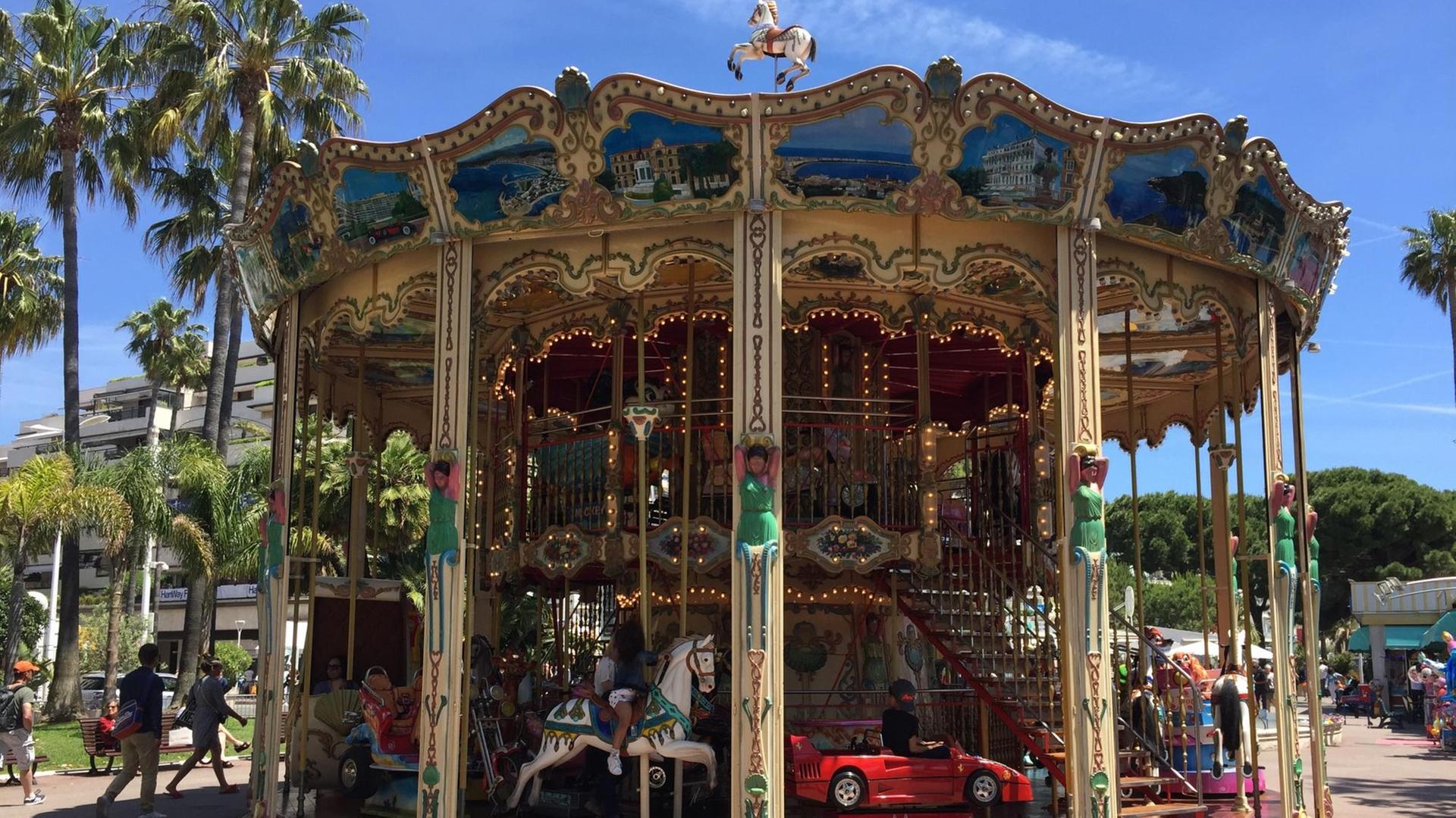 Eine Runde Karussell fahren auf der Croisette im französischen Cannes. Eine Runde Karussell fahren auf der Croisette im französischen Cannes.