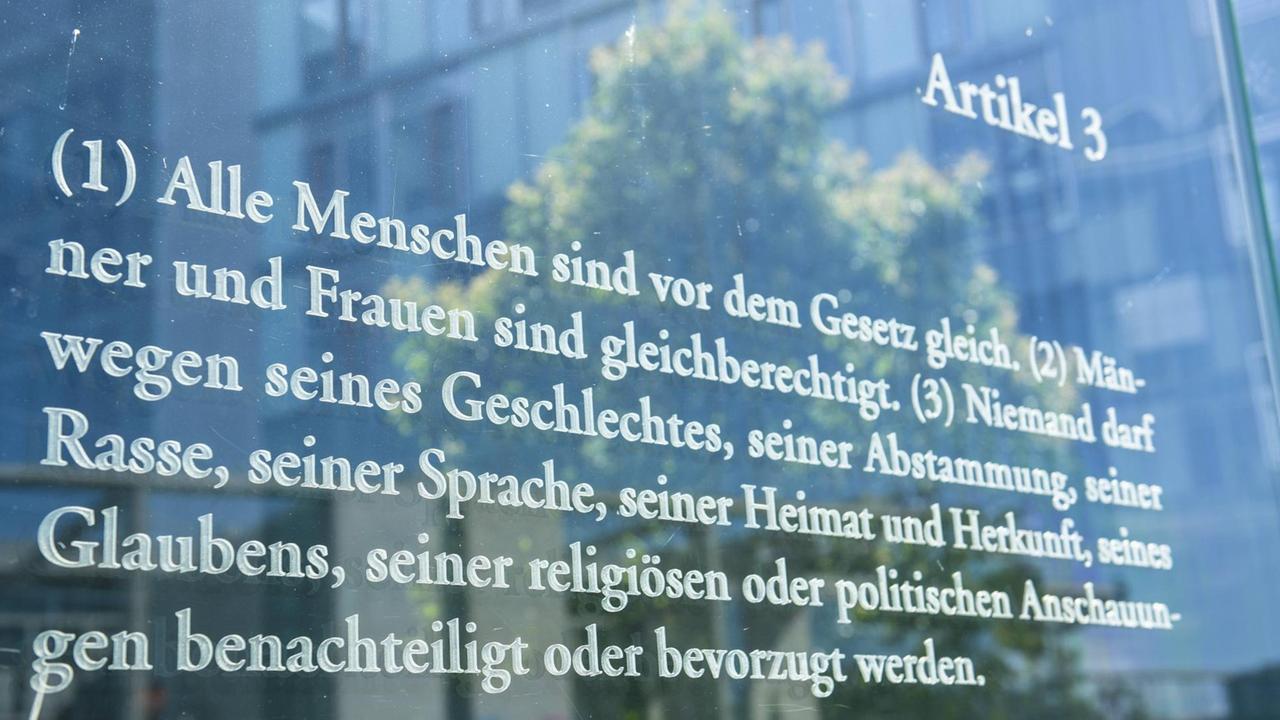 Der Wortlaut des Artikels 3 des deutschen Grundgesetzes auf einer Glaswand. Eine Installation von Dani Karavan. Der Wortlaut des Artikels 3 des deutschen Grundgesetzes auf einer Glaswand. Eine Installation von Dani Karavan.