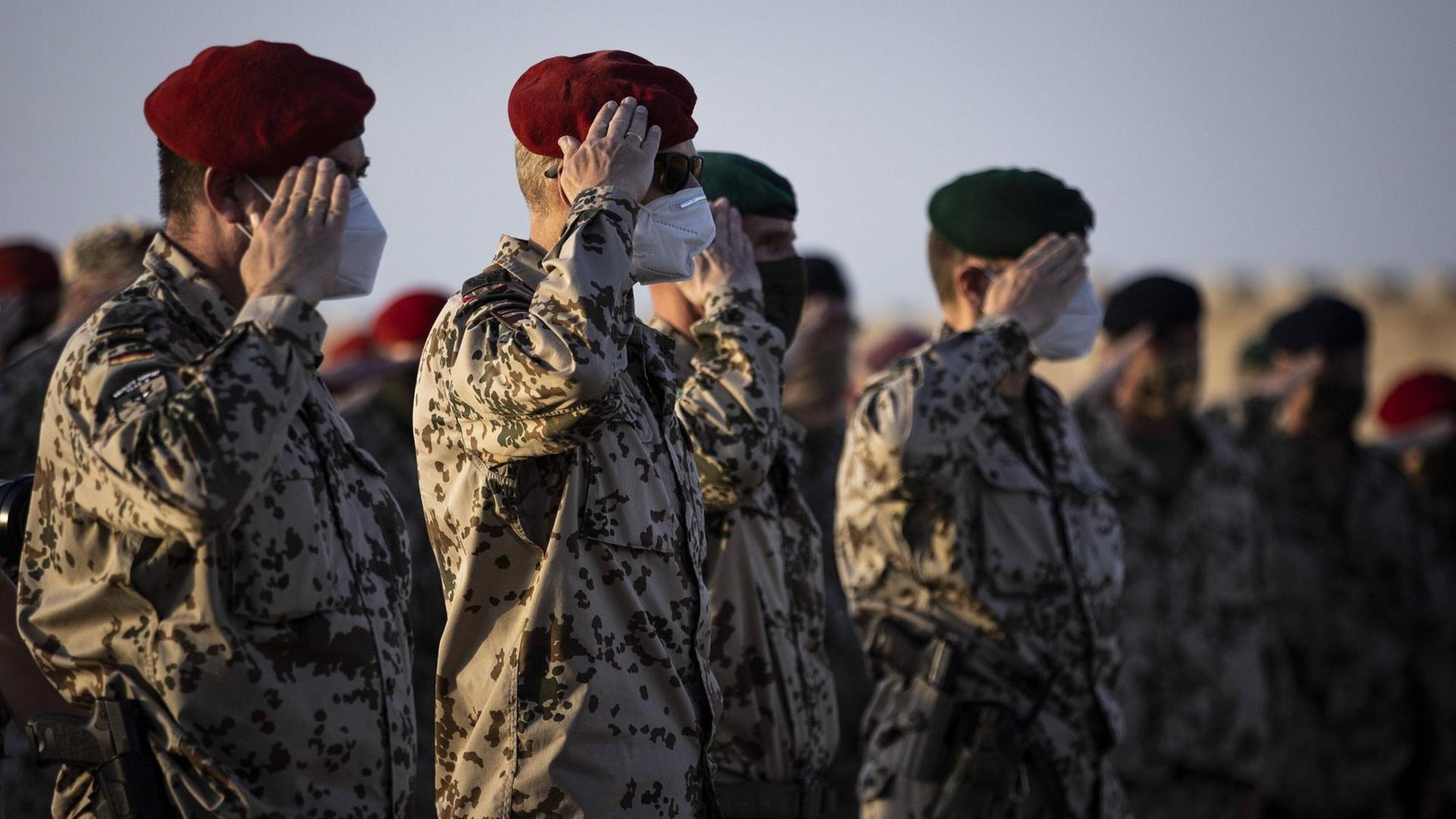 In Afghanistan salutieren Bundeswehrsoldaten in einer Reihe. In Afghanistan salutieren Bundeswehrsoldaten in einer Reihe.