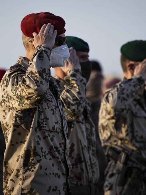 In Afghanistan salutieren Bundeswehrsoldaten in einer Reihe.