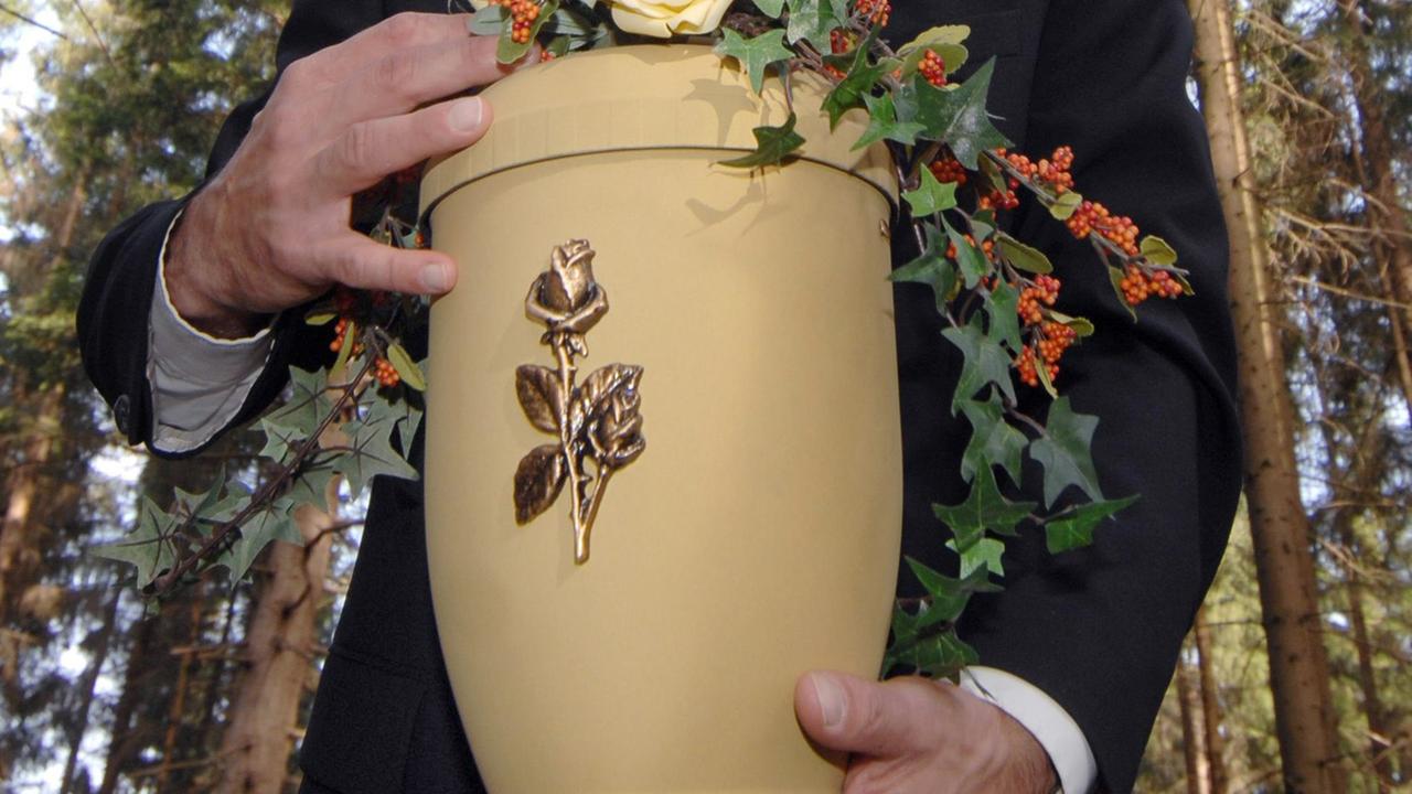 Eine Urne mit einer Rose auf der Vorderseite. Eine Urne mit einer Rose auf der Vorderseite.