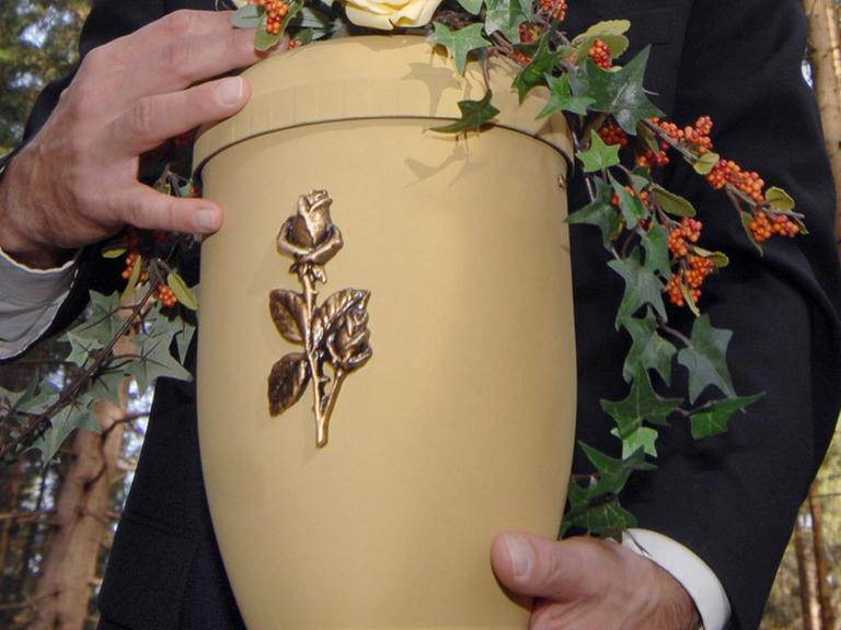 Eine Urne mit einer Rose auf der Vorderseite.