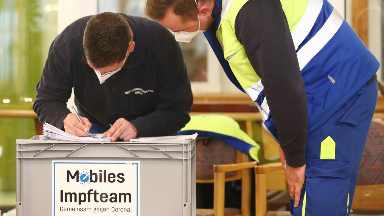 Mitarbeiter eines mobilen Impfteams bereiten die Corona-Impfungen im Seniorenpark Am Birkenwäldchen vor. Mitarbeiter eines mobilen Impfteams bereiten die Corona-Impfungen im Seniorenpark Am Birkenwäldchen vor.