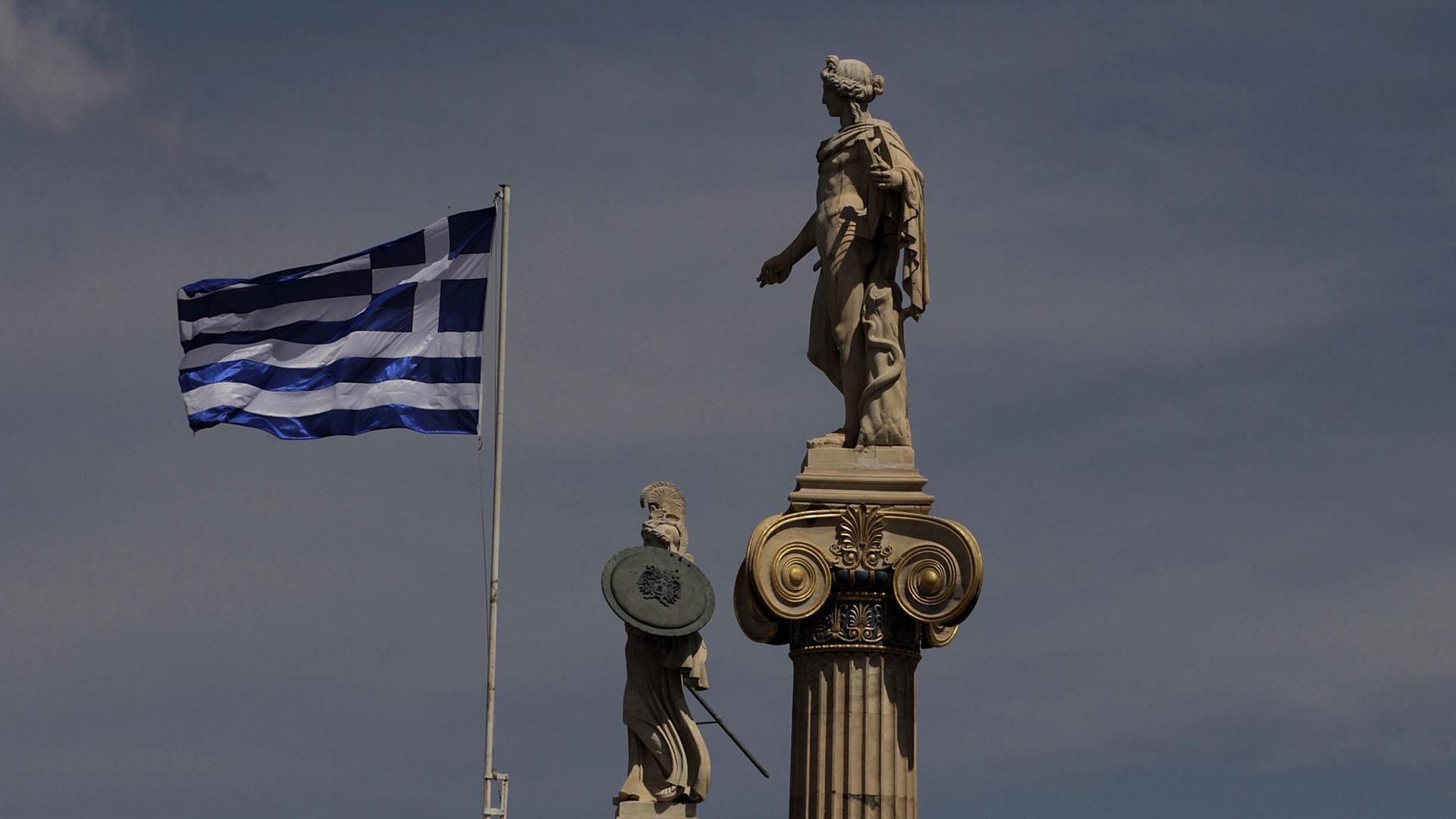 Die griechische Flagge weht neben den Statuen von Athene und Apollo vor der Akademie von Athen Die griechische Flagge weht neben den Statuen von Athene und Apollo vor der Akademie von Athen