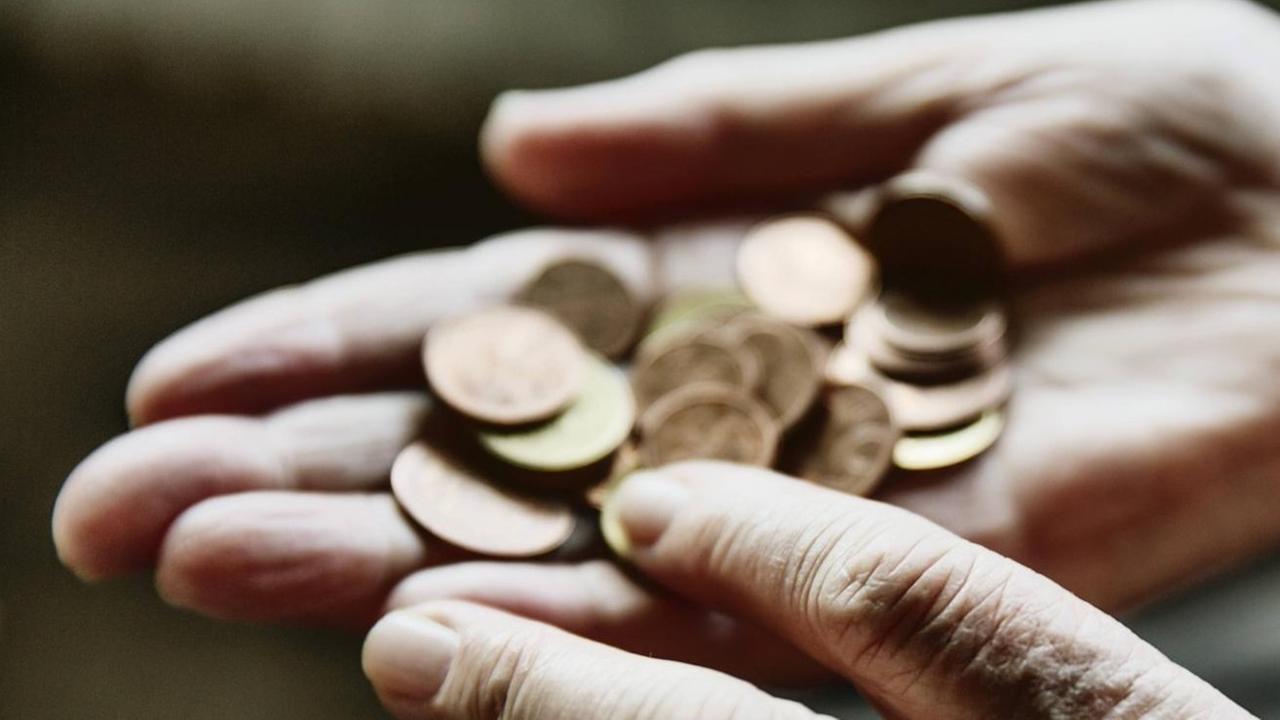 Nahaufnahme der Hand einer alten Frau, die ein paar Münzen zählt. Nahaufnahme der Hand einer alten Frau, die ein paar Münzen zählt.