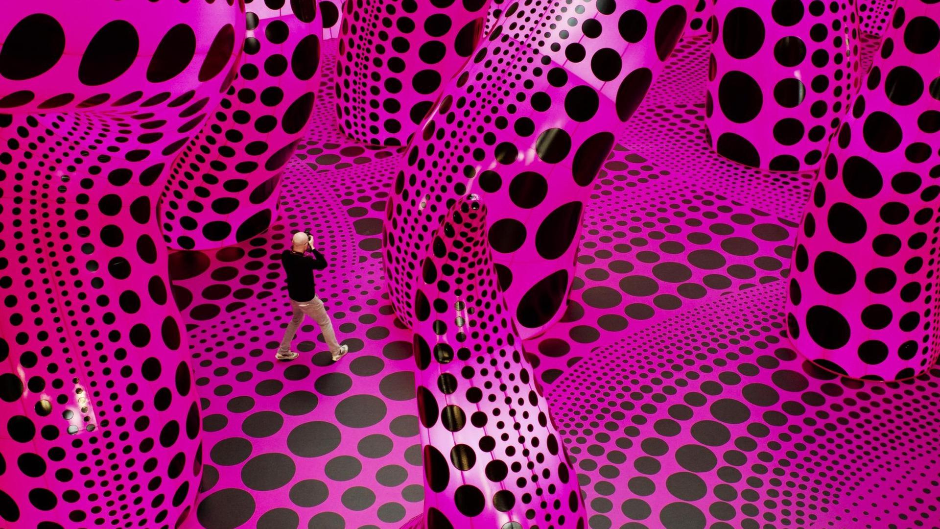 Ein Mann fotografiert das tentakel-artige Kunstwerk "A Bouquet of Love I Saw in the Universe" von Yayoi Kusama im Berliner Gropius Bau. Ein Mann fotografiert das tentakel-artige Kunstwerk "A Bouquet of Love I Saw in the Universe" von Yayoi Kusama im Berliner Gropius Bau.
