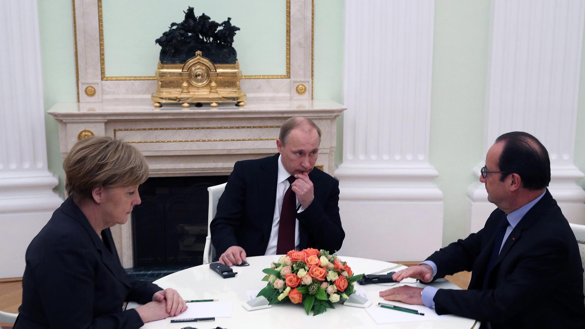 Angela Merkel, Francois Hollande und Wladimir Putin an einem Tisch im Kreml. Angela Merkel, Francois Hollande und Wladimir Putin an einem Tisch im Kreml.