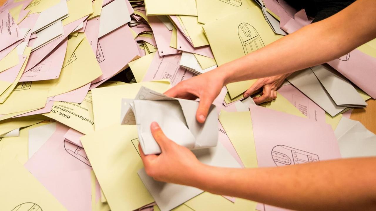 Eine Wahlhelferin leert in einem Wahllokal für die Stimmauszählung die Wahlurne mit den Stimmzetteln zur Wahl in Hamburg. Eine Wahlhelferin leert in einem Wahllokal für die Stimmauszählung die Wahlurne mit den Stimmzetteln zur Wahl in Hamburg.