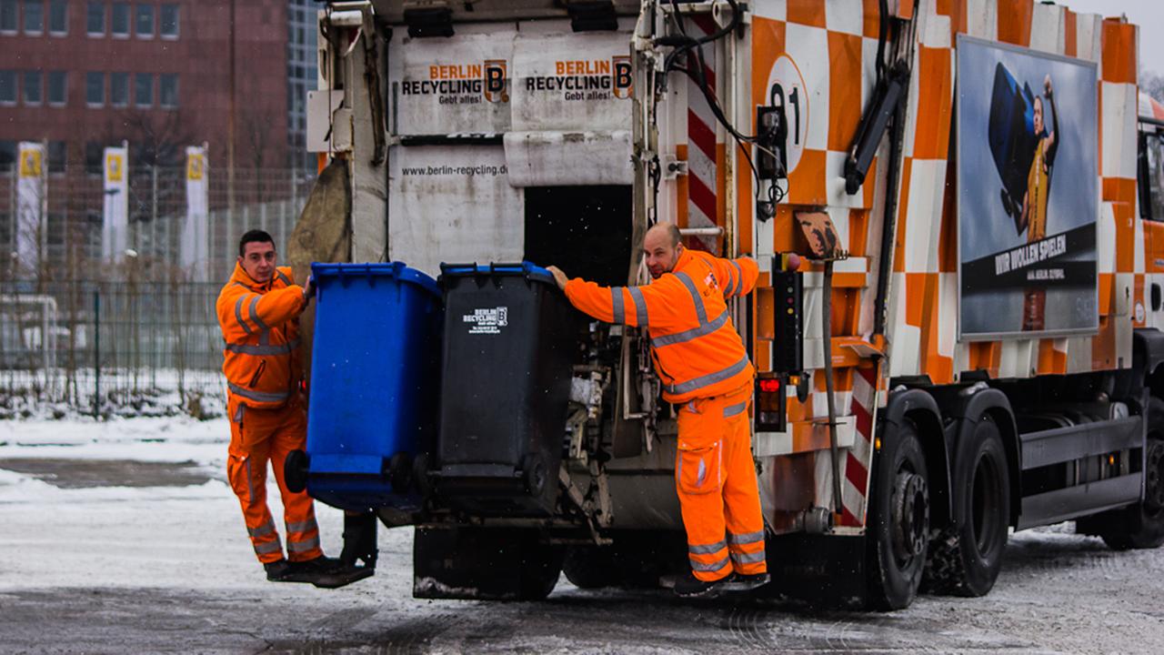 Zwei Müllmänner der Berlin Recycling GmbH auf Altpapiertour.