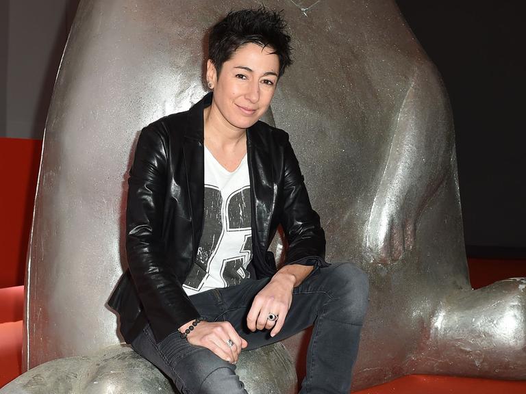 Die Moderatorin Dunja Hayali sitzt am 13.02.2015 in Berlin während der 65. Internationalen Filmfestspiele auf einer Skulptur.