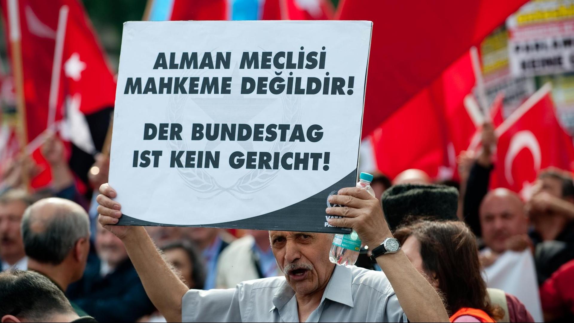 Teilnehmer der Demonstration halten ein Schild hoch mit dem Slogan "Der Bundestag ist kein Gericht". Teilnehmer der Demonstration halten ein Schild hoch mit dem Slogan "Der Bundestag ist kein Gericht".