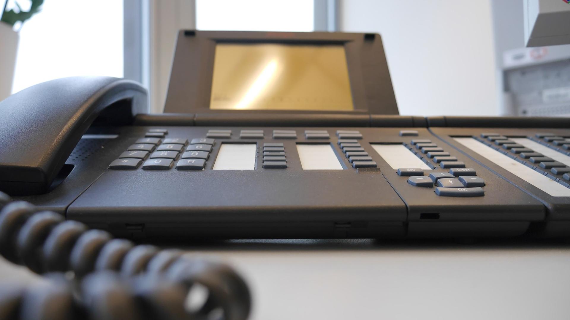 Ein Telefon steht auf einem Schreibtisch in einem Sekretariat. Ein Telefon steht auf einem Schreibtisch in einem Sekretariat.