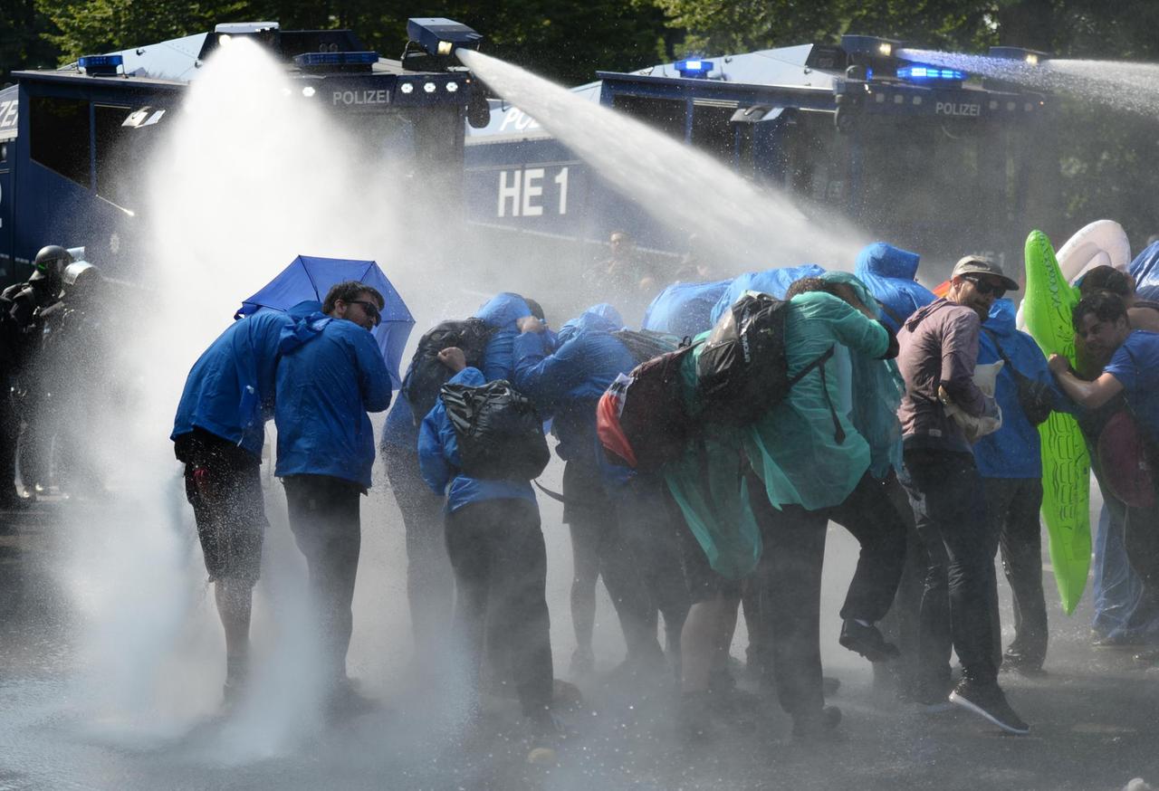 Die Polizei räumt mit Wasserwerfern eine Sitzblockade von Demonstranten im Hamburger Schanzenviertel
