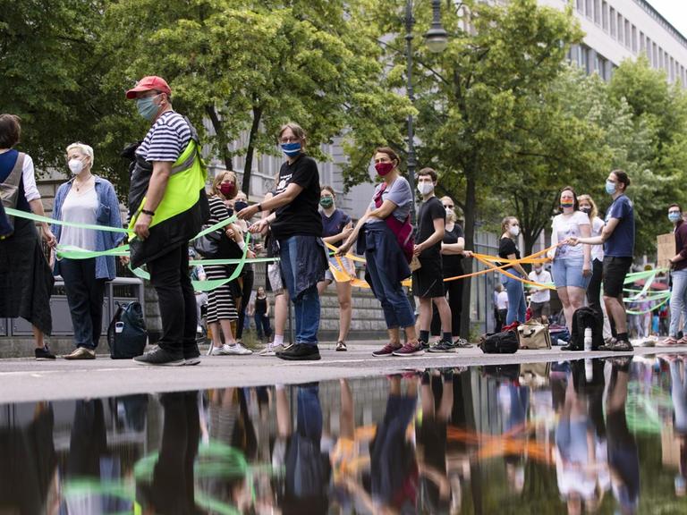 Demonstranten bilden eine menschliche Kette vom Brandenburger Tor zum Hermannplatz, indem sie soziale Distanz wahren, um am 14. Juni 2020 in Berlin gegen soziale Ungerechtigkeit und Rassismus zu protestieren.