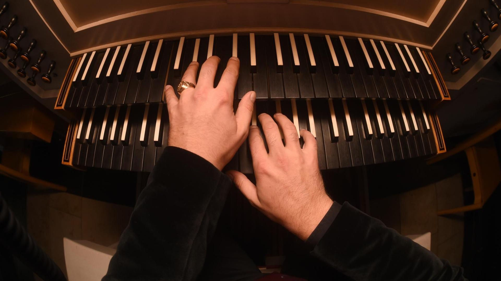 Hände eines Orgelspielers spielen am 12.10.2015 in München-Neuaubing (Bayern) in der Kirche St.Konrad die Tasten einer Orgel. Hände eines Orgelspielers spielen am 12.10.2015 in München-Neuaubing (Bayern) in der Kirche St.Konrad die Tasten einer Orgel.