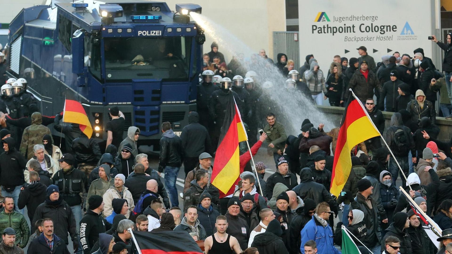 Mit einem Wasserwerfer drängen Polizisten Kundgebungsteilnehmer zurück. Mit einem Wasserwerfer drängen Polizisten Kundgebungsteilnehmer zurück.