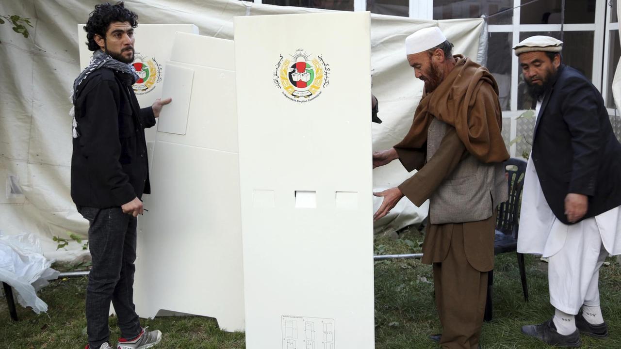 Afghanische Wahlhelfer bereiten sich auf die Wahl in einem Wahllokal vor den Parlamentswahlen. Afghanische Wahlhelfer bereiten sich auf die Wahl in einem Wahllokal vor den Parlamentswahlen.