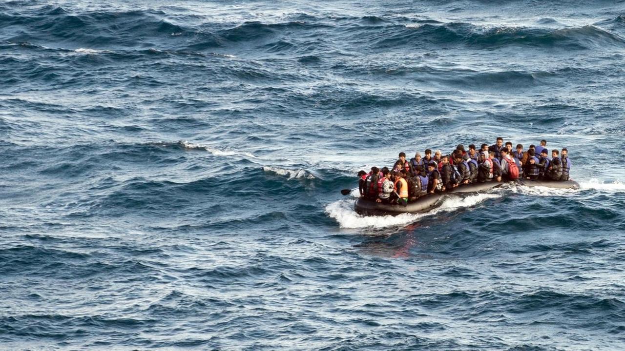 Ein vollgepacktes Schlauchboot mit Flüchtlingen auf dem Meer