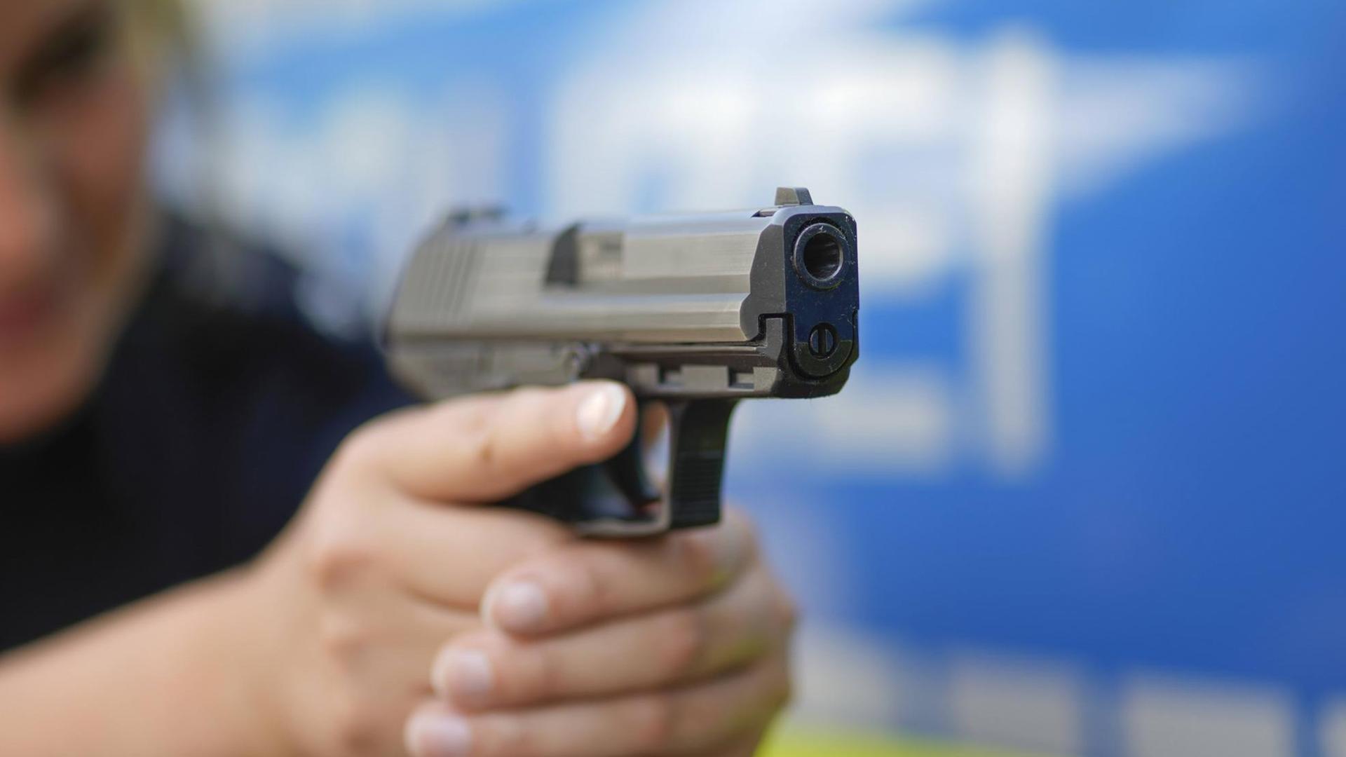Eine Polizeibeamtin zielt mit einer Pistole (Symbolbild) Eine Polizeibeamtin zielt mit einer Pistole (Symbolbild)