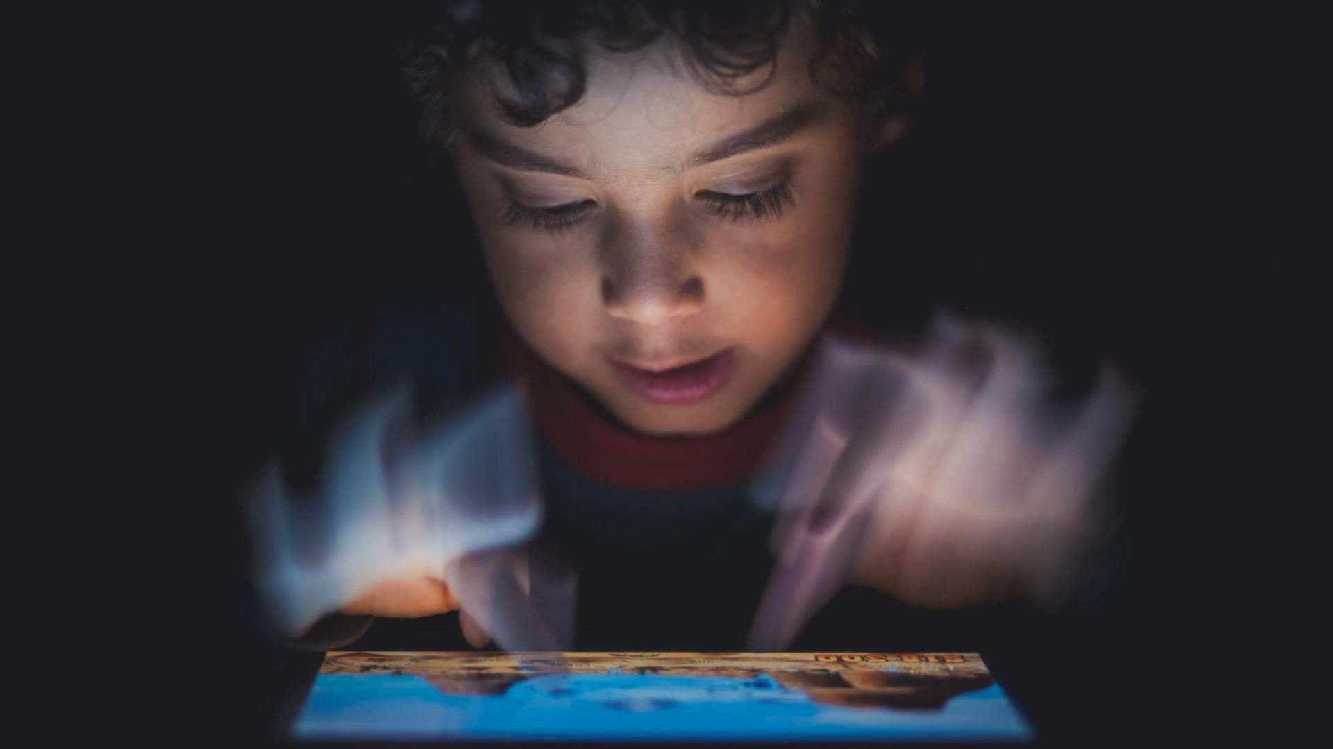 Ein Kind spielt ein Videospiel auf einem Tablet-Computer. Ein Kind spielt ein Videospiel auf einem Tablet-Computer.