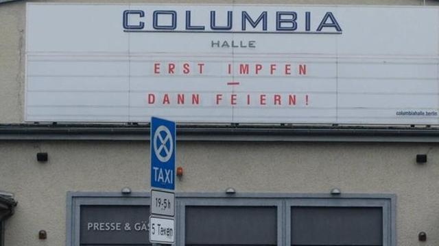 Anzeigetafel des Columbia Theaters am Columbia Damm in Berlin-Kreuzberg mit der Aufschrift "Erst Impfen - dann Feiern"