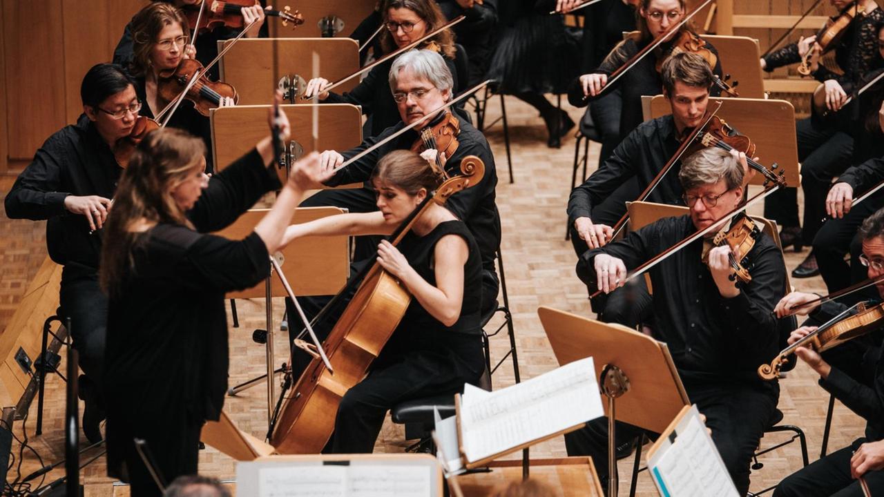 Die Cellistin im Kreise des Orchesters Die Cellistin im Kreise des Orchesters