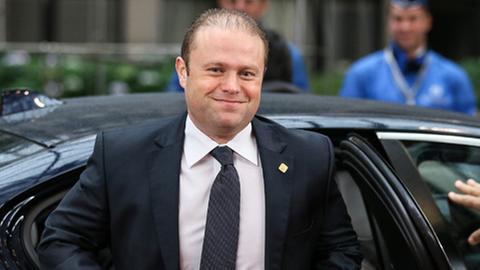 Maltas Premier Muscat steigt aus einem Auto und knöpft sich das schwarze Anzugsakko zu