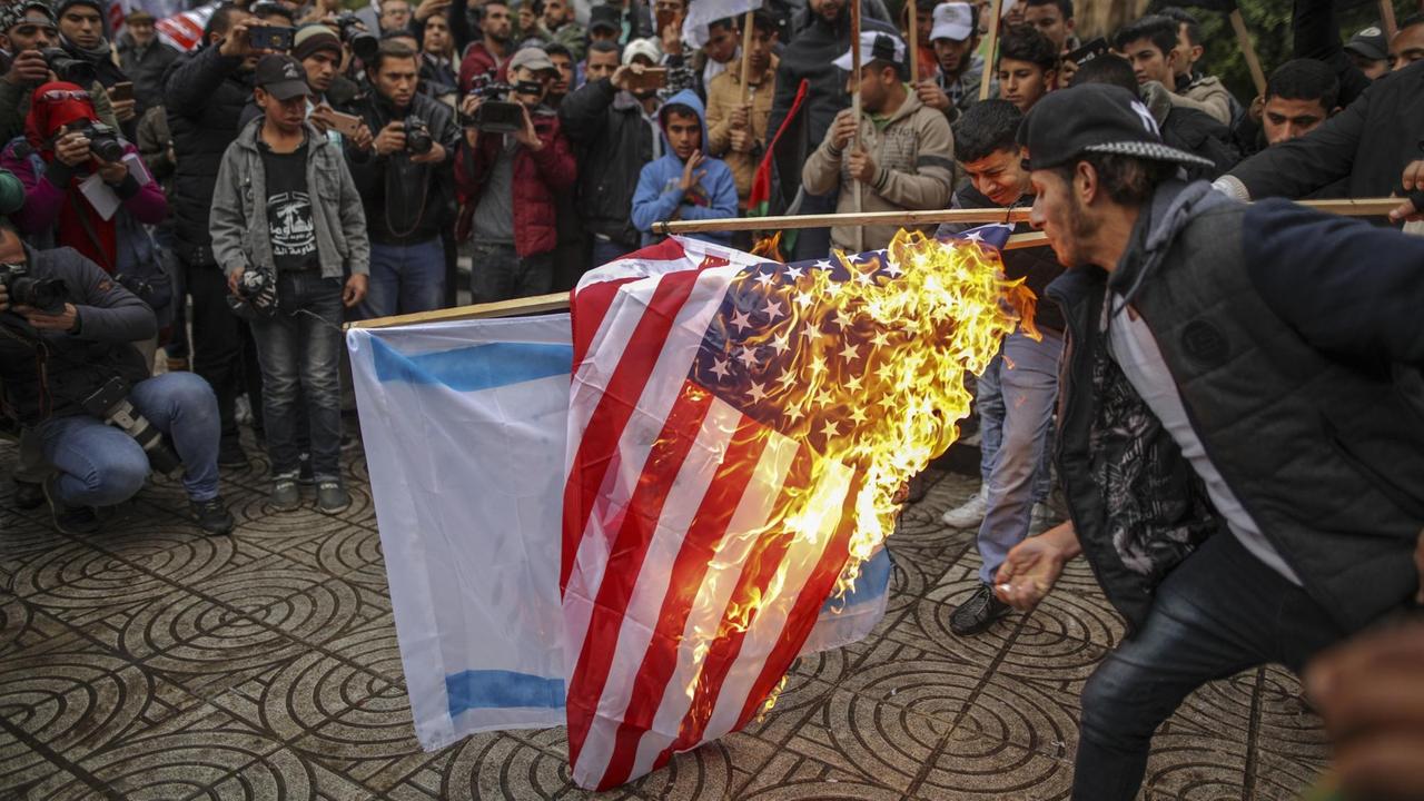Palästinenser verbrennen am 06.12.2017 in Gaza (Palästinensische Autonomiegebiete) während eines Protests gegen US-Präsident Trumps Vorhaben, Jerusalem als Hauptstadt Israels anzuerkennen, die amerikanische und israelische Flagge. (zu dpa «Trump legt mit Jerusalem die Lunte an das Pulverfass Nahost» vom 06.12.2017) Palästinenser verbrennen am 06.12.2017 in Gaza (Palästinensische Autonomiegebiete) während eines Protests gegen US-Präsident Trumps Vorhaben, Jerusalem als Hauptstadt Israels anzuerkennen, die amerikanische und israelische Flagge. (zu dpa «Trump legt mit Jerusalem die Lunte an das Pulverfass Nahost» vom 06.12.2017)