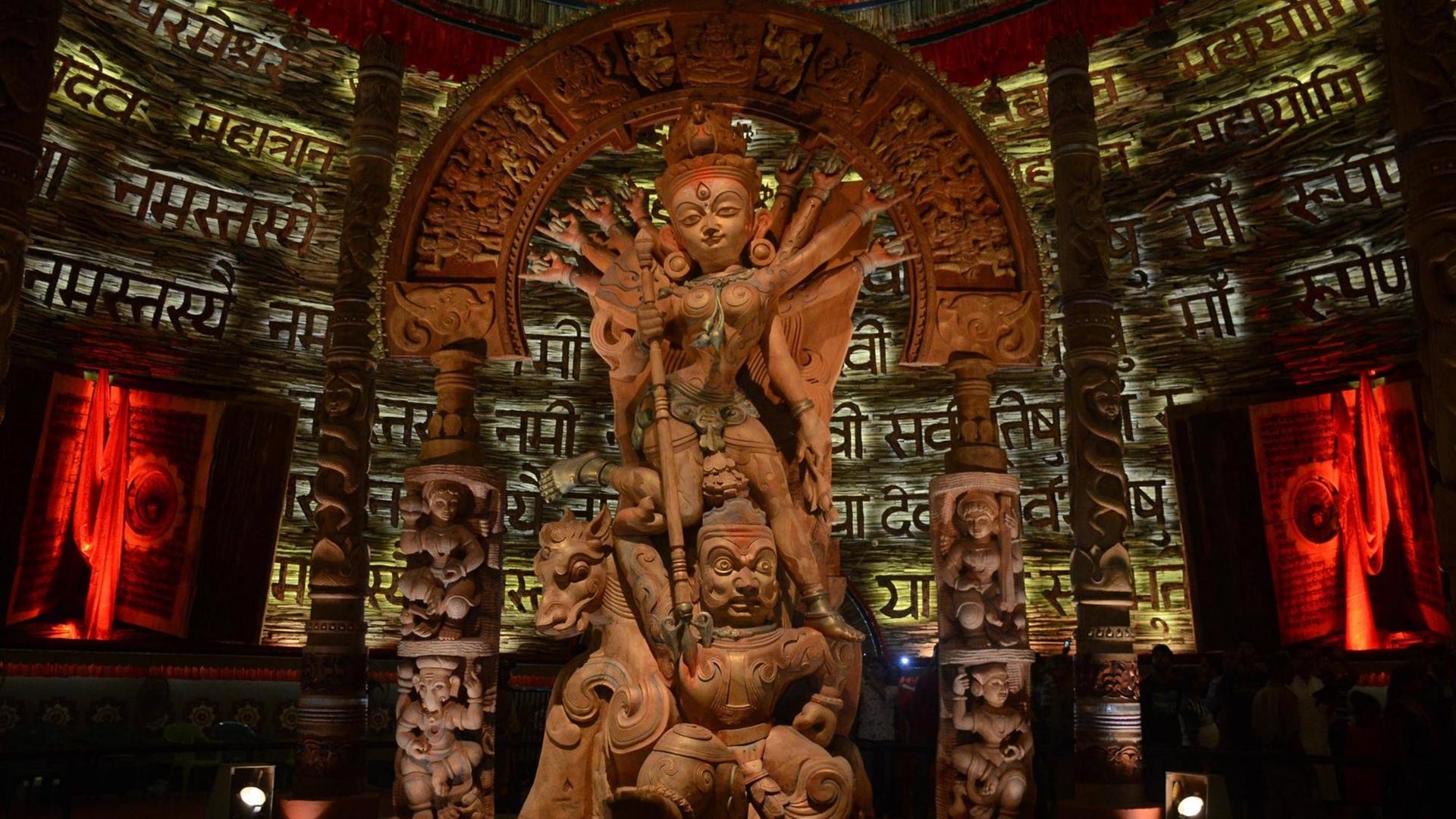 Eine hölzerne Statue der Göttin Durga, im Kampf mit dem Dämon Mahisha. Aufgenommen auf dem Navratri-Fest in Kolkata, Indien. Eine hölzerne Statue der Göttin Durga, im Kampf mit dem Dämon Mahisha. Aufgenommen auf dem Navratri-Fest in Kolkata, Indien.