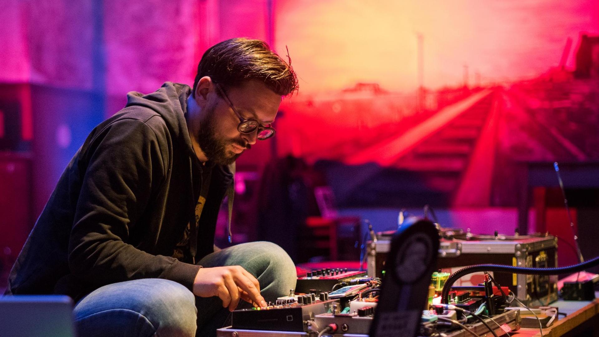 Achim Zepezauer sitzt vor seinem elektronischen Tisch und tüftelt an Klängen