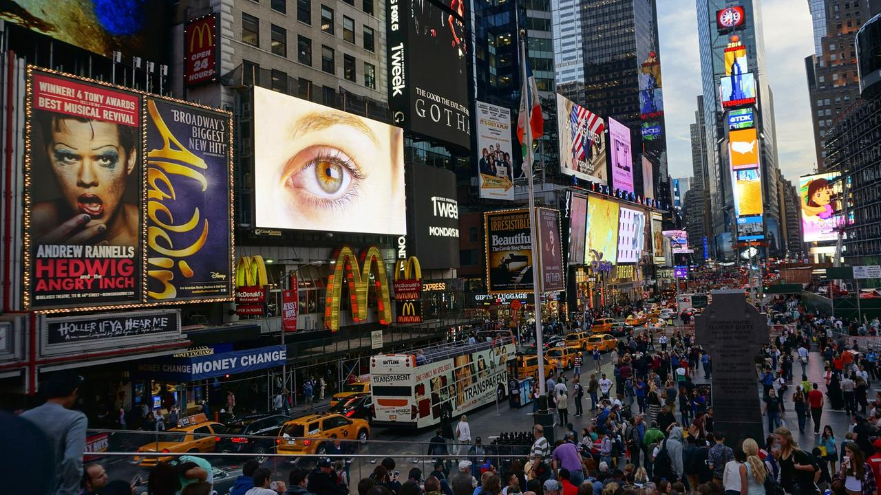 Der Times Square in New York mit zahllosen Reklametafeln an Häuserwänden und auf Fahrzeugen. Der Times Square in New York mit zahllosen Reklametafeln an Häuserwänden und auf Fahrzeugen.