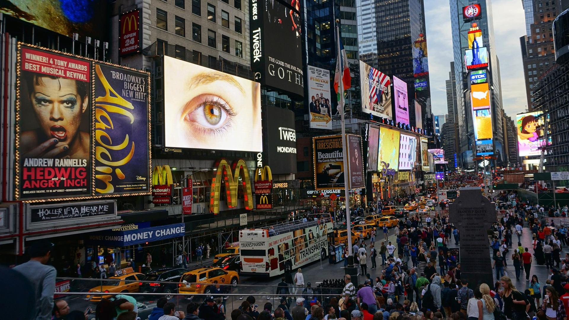 Der Times Square in New York mit zahllosen Reklametafeln an Häuserwänden und auf Fahrzeugen.