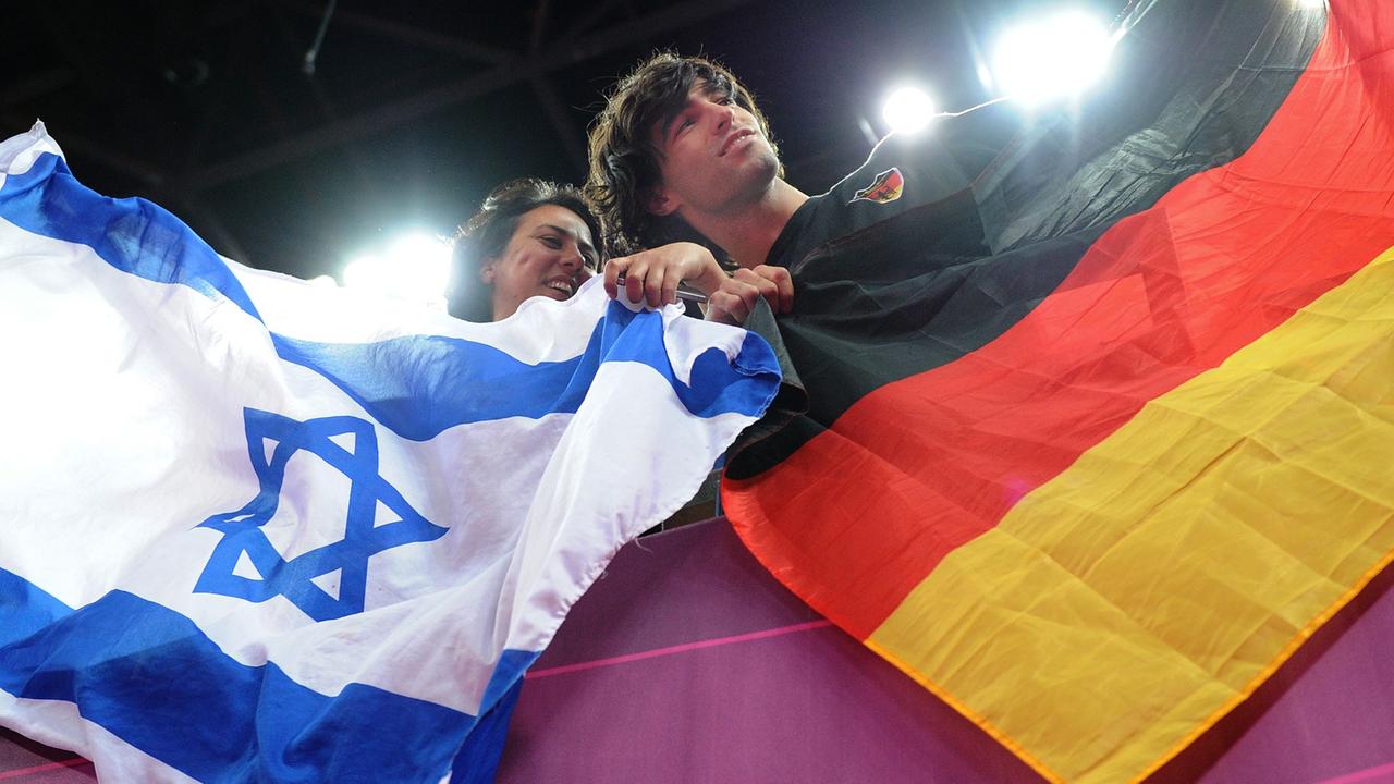Eine Frau und ein Mann mit einer israelischen und einer deutschen Flagge bei den Olympischen Spielen 2012 in London Eine Frau und ein Mann mit einer israelischen und einer deutschen Flagge bei den Olympischen Spielen 2012 in London
