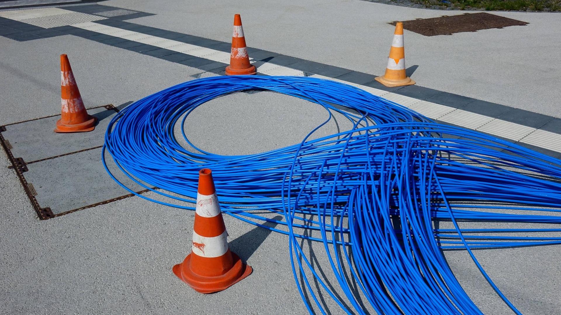 Blaue Glasfaserkabel liegen auf einem Bürgersteig in Luxemburg-Stadt, Luxemburg. Blaue Glasfaserkabel liegen auf einem Bürgersteig in Luxemburg-Stadt, Luxemburg.