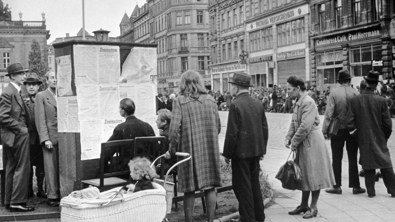 Historisches Foto: Passanten lesen in Berlin im Mai 1945 nach Kriegsende Zeitungen an einem Aushang an der Wiender Straße vor dem Goerlitzer Bahnhof.