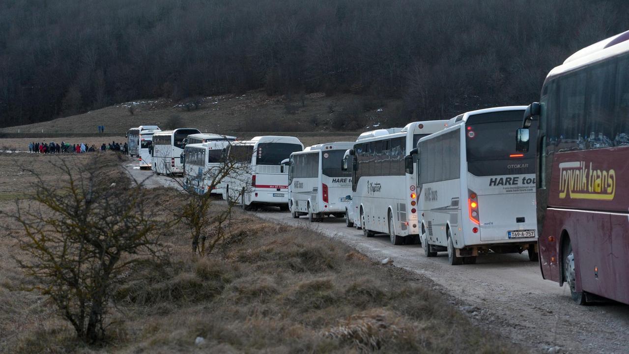 Busse stehen in der Nähe des aufgelösten Flüchtlingslagers Bihac in Bosnien bereit. Sie sollen die Flüchtlinge dort in andere Unterkünfte evakuiere