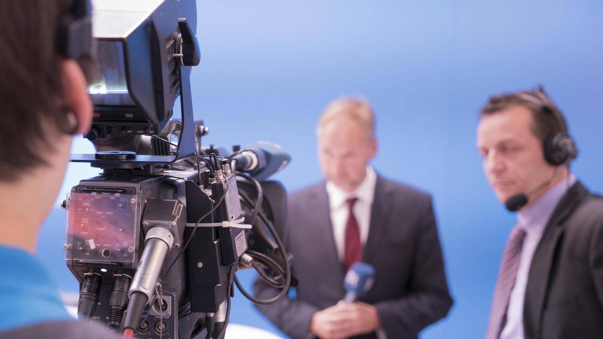 Ein Kameramann filmt einen Mann mit Mikrofon Ein Kameramann filmt einen Mann mit Mikrofon