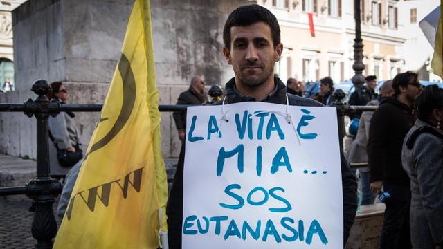 Ein Demonstrant bei einer Pressekonferenz in Rom zeigt ein Schild