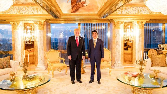 US-Präsident Donald Trump und Japans Ministerpräsident Shinzo Abe im Trump Tower in New York inmitten einer goldglänzenden Einrichtung.