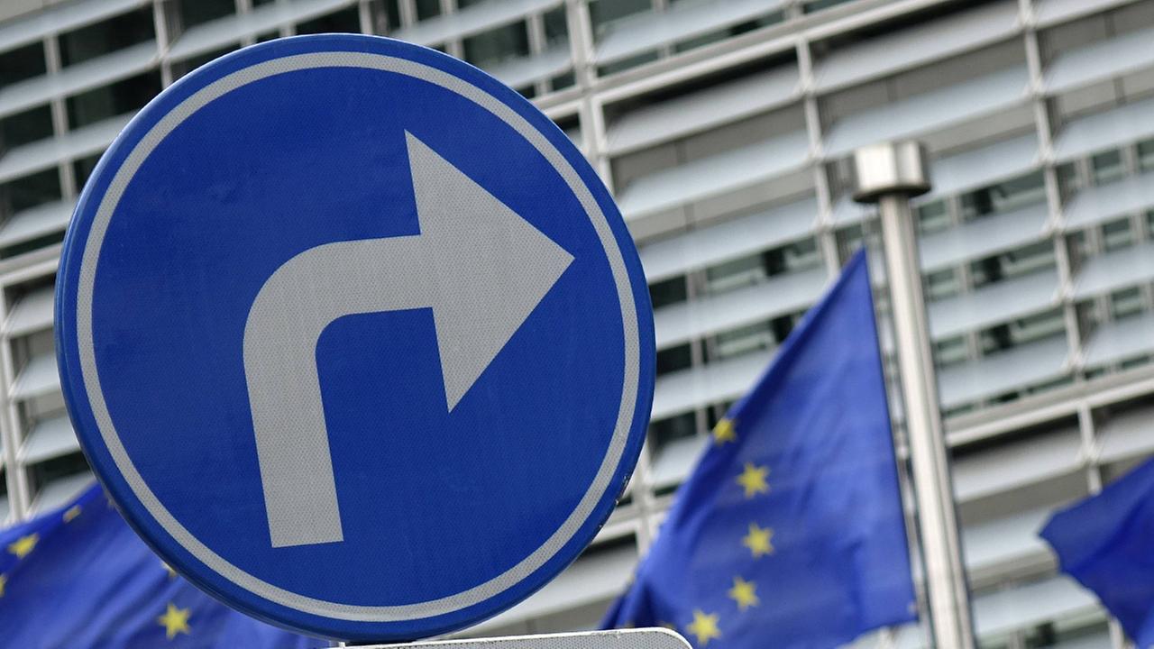 Ein Pfeil nach rechts vor einem Europa Gebäude in Brüssel Ein Pfeil nach rechts vor einem Europa Gebäude in Brüssel