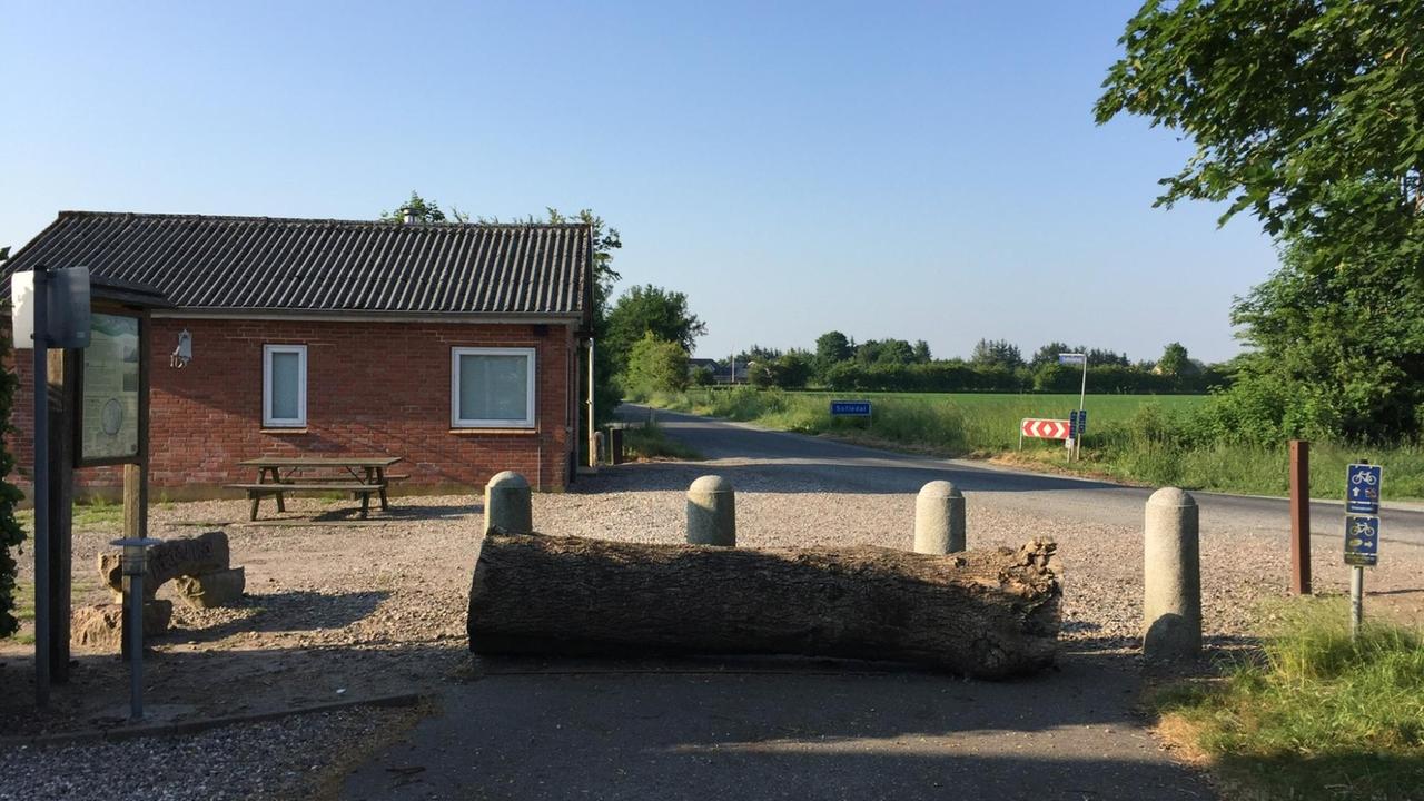 Grenzhäuschen mit Pollern und umgekipptem Baumstamm Grenzhäuschen mit Pollern und umgekipptem Baumstamm