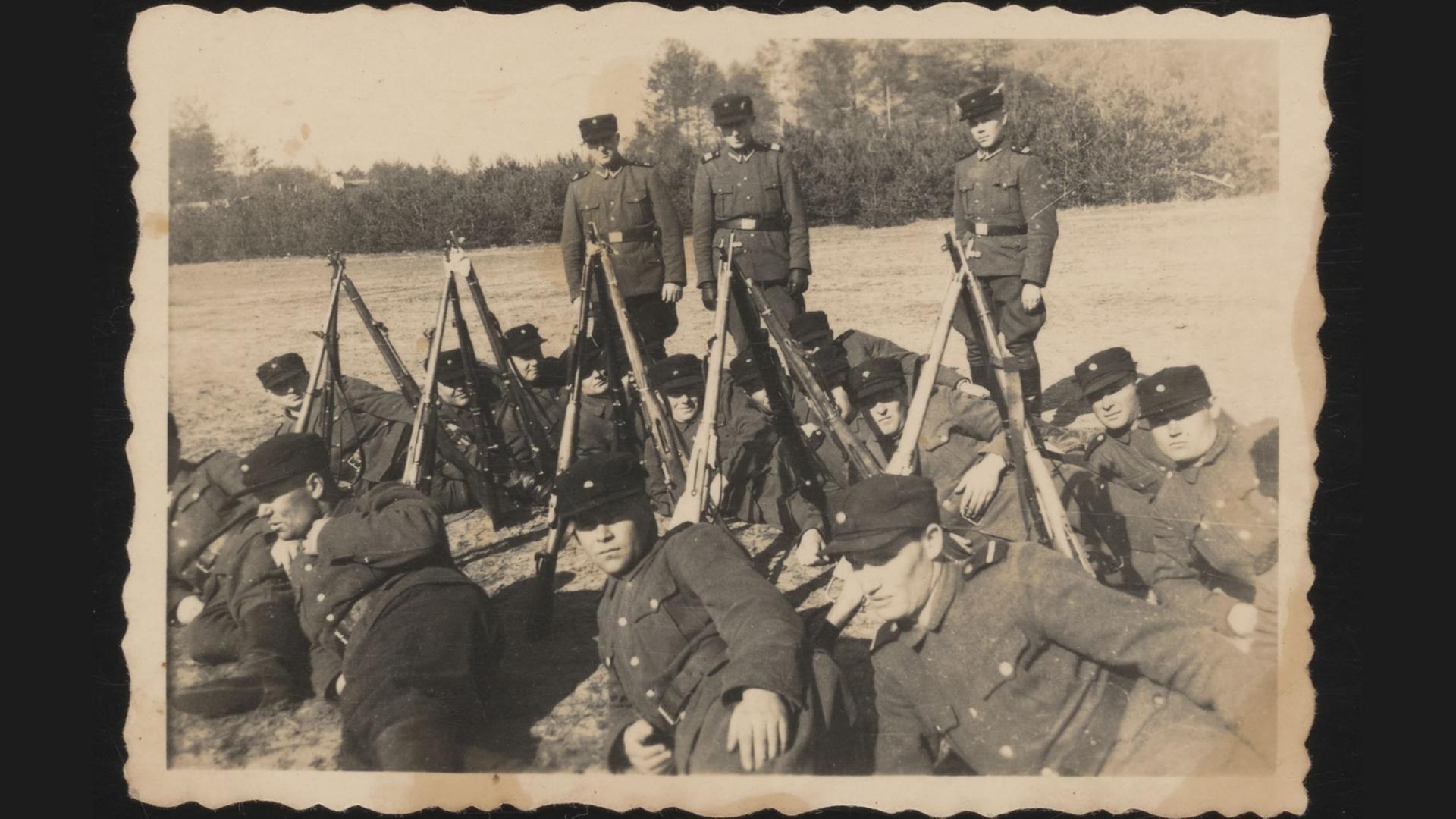 Eine Trawniki-Einheit im Frühjahr 1943 auf dem Exerzierplatz vor dem Lager Sobibor III. Der liegende Wachmann vorn in der Mitte ist möglicherweise Ivan Demjanjuk. Eine Trawniki-Einheit im Frühjahr 1943 auf dem Exerzierplatz vor dem Lager Sobibor III. Der liegende Wachmann vorn in der Mitte ist möglicherweise Ivan Demjanjuk.