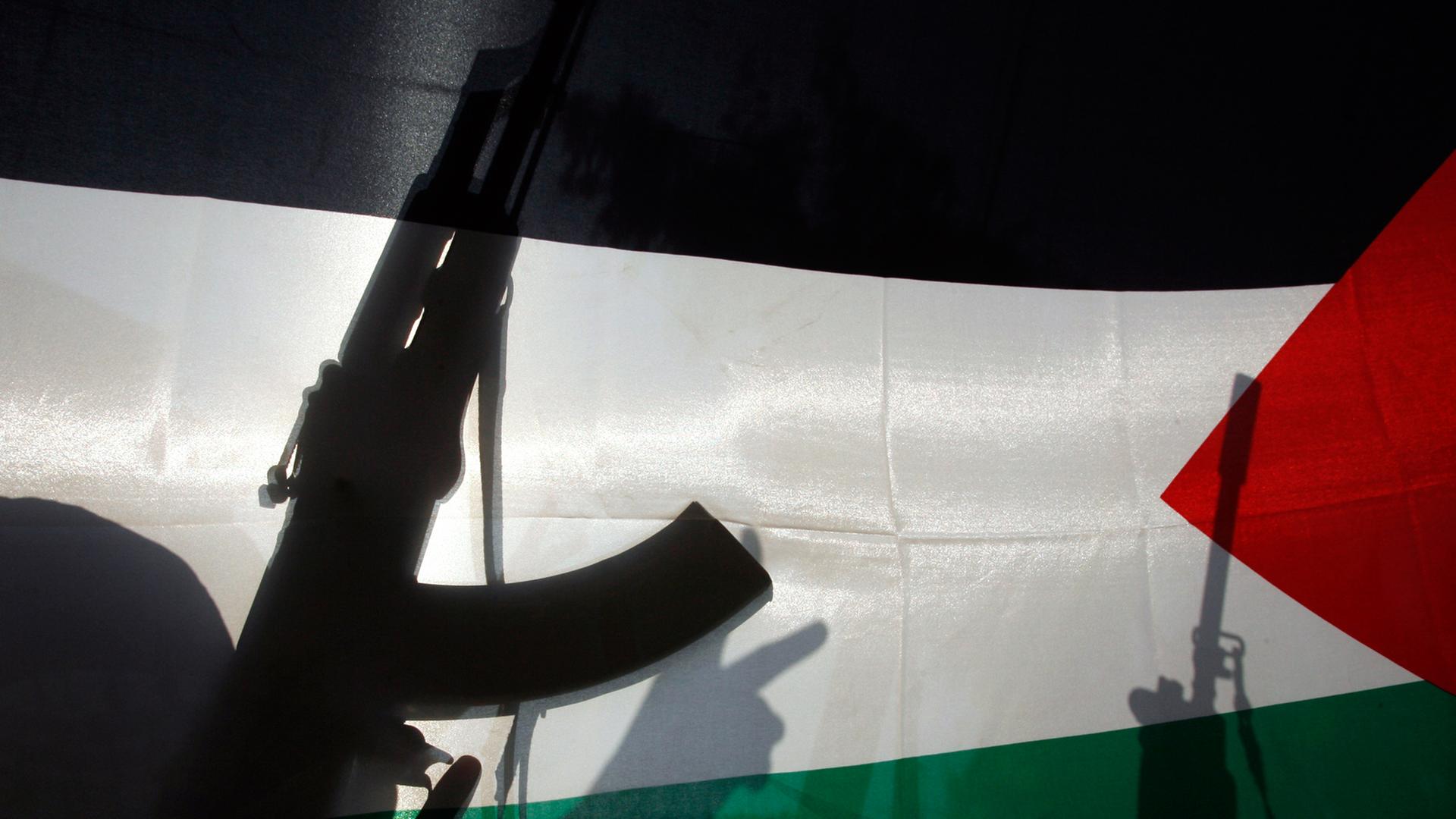 Palästinensische Aktivisten mit Waffen und ihrer Flagge Palästinensische Aktivisten mit Waffen und ihrer Flagge