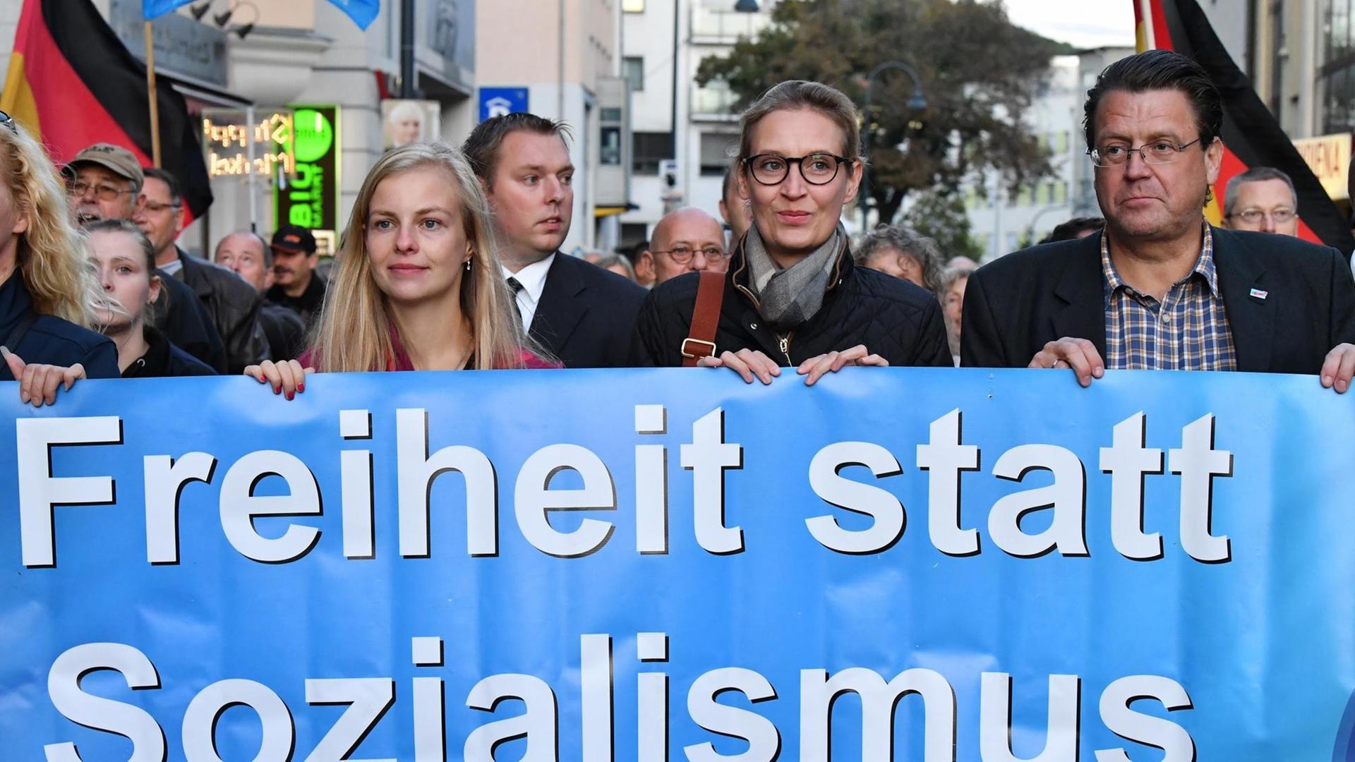 Alice Weidel (M), AfD-Spitzenkandidatin für die Bundestagswahl 2017, trägt am 12. September 2017 in Jena (Thüringen) gemeinsam mit den Thüringer AfD-Abgeordneten Wiebke Muhsal (l) und Stephan Brandner (r) während einer Wahlkampfveranstaltung der AfD ein Transparent mit der Aufschrift "Freiheit statt Sozialismus" Alice Weidel (M), AfD-Spitzenkandidatin für die Bundestagswahl 2017, trägt am 12. September 2017 in Jena (Thüringen) gemeinsam mit den Thüringer AfD-Abgeordneten Wiebke Muhsal (l) und Stephan Brandner (r) während einer Wahlkampfveranstaltung der AfD ein Transparent mit der Aufschrift "Freiheit statt Sozialismus"