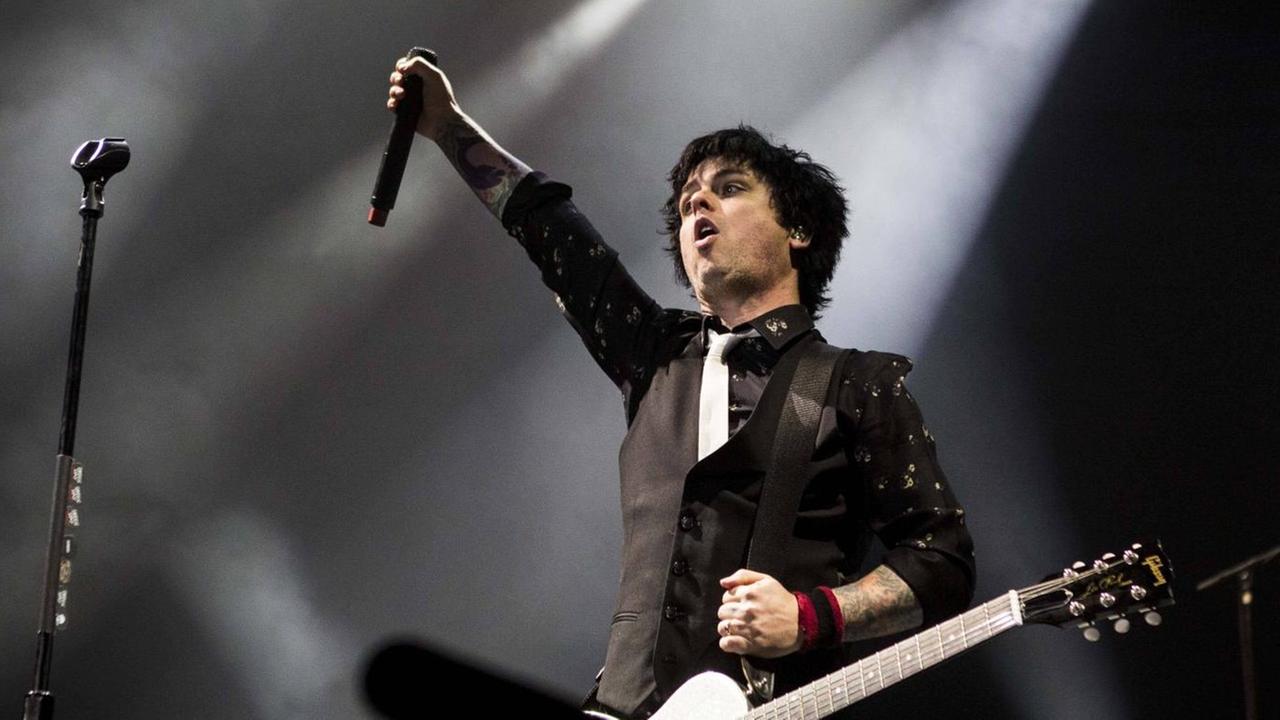 Billie Joe Armstrong von der US-Punkband Green Day steht auf einer Konzertbühne und reckt eine Faust hoch. Billie Joe Armstrong von der US-Punkband Green Day steht auf einer Konzertbühne und reckt eine Faust hoch.